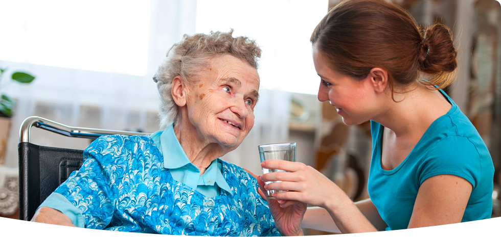 caregiver giving water to patient